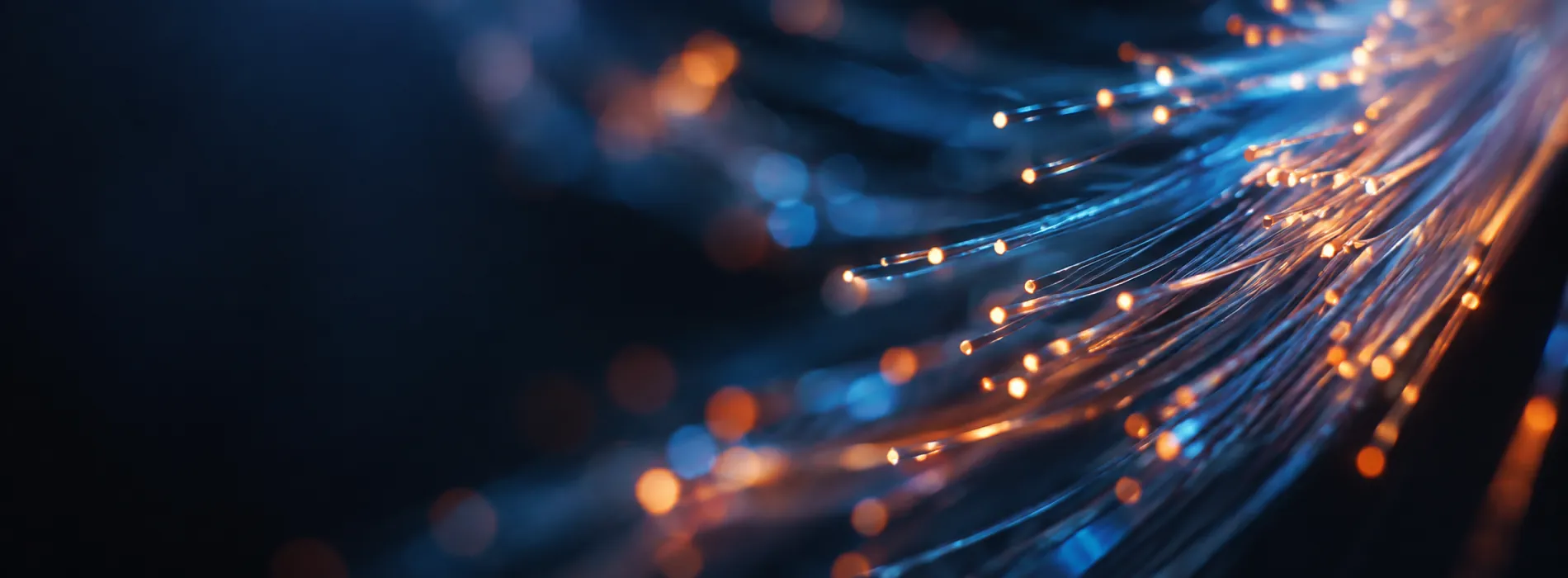 Glowing blue and orange fibre-optic strands curving through darkness