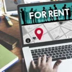bigstock-For-Rent-Rental-Available-Rent-116961809 - Kihan Marketing Laptop screen shows a 'FOR RENT' banner over a city map with a red location pin and silhouettes in the banner area.