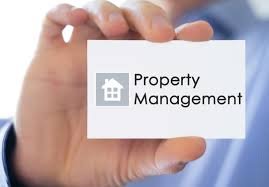 Hand holding a white card displaying a small house icon and the words 'Property Management'