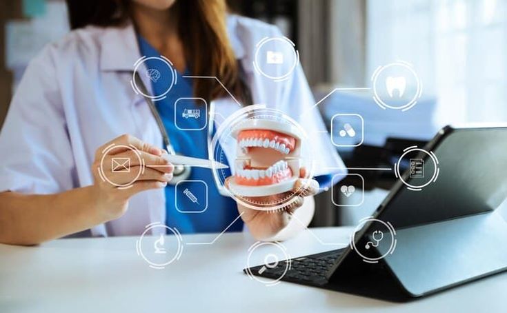 49ff92c366307600bd9bcb609728db39 - Kihan Marketing - Kihan Marketing Dental professional in a lab coat uses a dental model with a tablet showing holographic icons, illustrating digital dentistry tech.