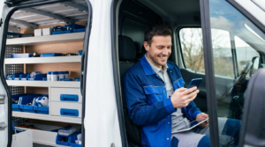 Service business owner checking new customer leads on a smartphone inside a work van