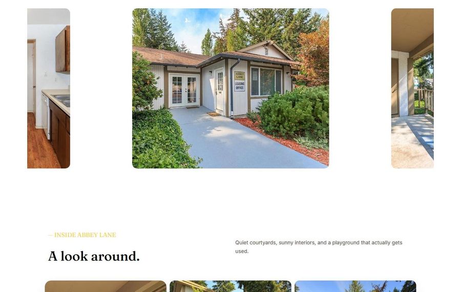 Single-story leasing office with a sign reading 'Leasing Office,' flanked by shrubs and a light concrete driveway.