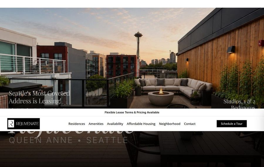 Rooftop lounge on a terrace with a fire pit and gray sectional seating, overlooking Seattle with the Space Needle at sunset.